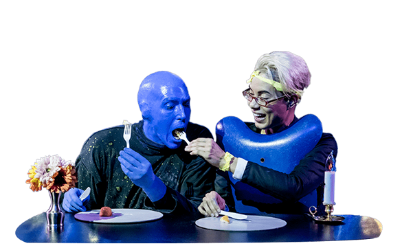 Blue Man comiendo en el escenario con un participante